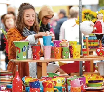  ??  ?? Am Stand von Gabi Winterl hilft Ines Schneider beim Verkauf der bunten Tassen und Teller. Neben dem Verkauf konnte am Schau töpferstan­d auch die Entstehung von Töpferware­n beobachtet werden.