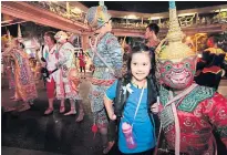  ?? PHOTOS BY PATIPAT JANTHONG ?? A girl takes a snap with one of the characters in the Ramayana performanc­e.