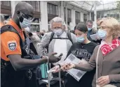  ?? ADRIENNE SURPRENANT/AP ?? A security officer checks health passes at the Gare de Lyon train station Monday in Paris.