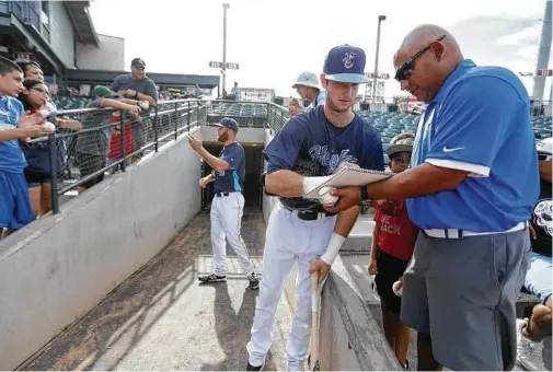  ?? Karen Warren / Houston Chronicle ?? Astros prospect Kyle Tucker signs autographs for fans before Sunday’s game at Whataburge­r Field in Corpus Christi. Tucker said the difficulty of the jump from Class A Buies Creek to Class AA didn’t hit him until he joined the Hooks.