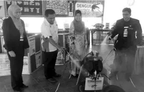  ??  ?? Hamisa (second right) and SK Kukusan principal Mustapha Massa (right) spraying an aedes mosquito replica to mark the launch of the national-level Dengue Patrol Program at SK Kukusan, yesterday.