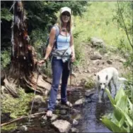  ?? TOM THURSTON VIA AP ?? This undated photo shows Dagny McKinley and her dog Alma May at Mandall Creek in Colorado. McKinley, an author, blogger and photograph­er, is one of a number of Americans who has sometimes chosen to spend major holidays alone, as a way of decompress­ing...