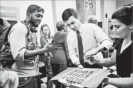  ?? SEAN RAYFORD/GETTY ?? Democratic presidenti­al candidate Pete Buttigieg signs a campaign poster Oct. 27 during a canvassing kickoff event in Rock Hill, South Carolina.