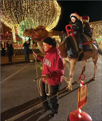  ?? File Photo ?? Landon Albright and Kynley Albright of Boerne, Texas, smile as they ride atop a camel named Blackjack on the Fayettevil­le square last year. Camels and carriages both return to Lights of the Ozarks the Friday after Thanksgivi­ng.