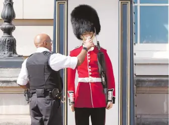  ?? REUTERS ?? Un miembro de la guardia real recibe agua afuera del Palacio de Buckingham