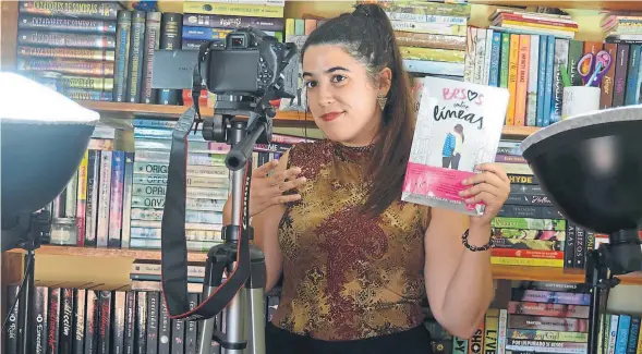  ?? M. R. A ?? La joven booktuber May R. Ayamonte en su habitación de Huelva donde graba los vídeos que después sube a su canal de Youtube; en la imagen con su libro