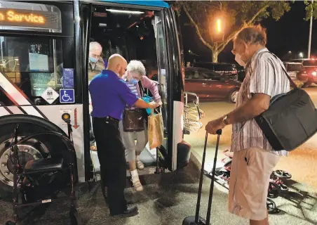  ?? Matthias Gafni / The Chronicle ?? Chris Tietze (right) waits for his parents, Doris and Armin, both 91, after they were evacuated by bus from Oakmont Gardens.