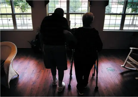  ?? AP FILE PHOTO ?? An elderly couple walks inside an assisted living facility in Illinois. According to a study released Monday, a bone-strengthen­ing drug given intravenou­sly every 18 months greatly lowered the risk of fracture in certain older women.