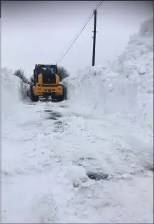  ??  ?? Machinery clearing a path through drifts in North Wexford.