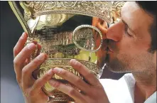  ?? REUTERS ?? Djokovic kisses the trophy after claiming a record-tying 20th Grand Slam title at Wimbledon on Sunday.