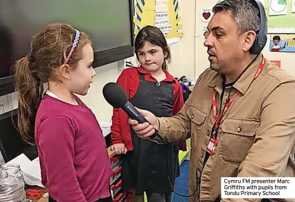  ?? ?? Cymru FM presenter Marc Griffiths with pupils from Tondu Primary School