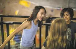  ??  ?? Abbie Cheng, 13, with fellow rock climbers Ruby Raffo-Day, 11, and Zaihra Roux Jacobo, 10, at Planet Granite in San Francisco.