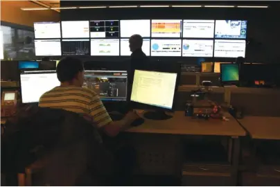  ?? STAFF PHOTO ?? Two men man the EPB Fiber Optic control room in 2015. Chattanoog­a and San Jose, Calif., were chosen from a field of three dozen cities to pilot adoption of new technologi­es being developed by the G20 Global Smart Cities Alliance.