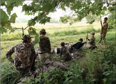  ?? NWA Democrat-Gazette/FLIP PUTTHOFF ?? Jeremy Wilson (left) and Chad Yoes (right) hunt with their sons on opening day of Arkansas’ dove season, Sept. 2. The dads used the hunt to teach the boys about nature and wildlife, and also English, math and other subjects they study in school.