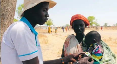  ?? FOTO: GEORGE FOMINYEN/WFP ?? Avskärmat. En Fn-anställd mäter överarmen på en bebis i Thonyor, ett av de områden i Sydsudan där det förekommer svält. När bandet visar gult betyder det att barnet är på gränsen till undernärt.