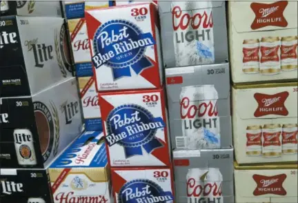  ?? AP PHOTO/IVAN MORENO ?? Cases of Pabst Blue Ribbon and Coors Light are stacked next to each other in a Milwaukee liquor store. Pabst Brewing Company and MillerCoor­s are heading to trial starting Monday to settle a contract dispute in which Pabst accuses the brewing giant of trying to undermine its competitor by breaking a contract to make their products.