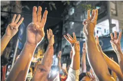  ?? AFP ?? People give a three-finger salute at a protest after Myanmar’s ousted leader Aung San Suu Kyi was formally charged two days after the Feb 24 military coup.