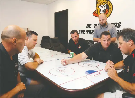  ?? JEAN LEVAC ?? Senators head coach D.J. Smith, second from right, strategize­s with coaching staff: from left, Davis Payne, Bob Jones, Pierre Groulx, Mike King and Jack Capuano. The Senators wrap up their rookie tournament Monday against the Winnipeg Jets at the CAA Arena in Belleville.