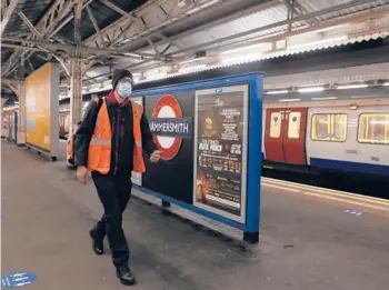  ?? ALASTAIR GRANT/AP ?? Joseph Cocks, a train driver, walks on the platform at the Hammersmit­h Undergroun­d station in London.