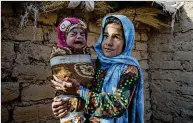  ?? ?? In Afghanista­n this year, about 3.2 million children younger than 5 years old are expected to suffer from acute malnutriti­on, according to the U.N.
◄ Qandi Gul holds her brother outside their home near Herat, Afghanista­n. Gul’s father sold her into marriage without telling his wife, taking the money to feed his five children.