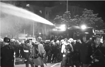  ??  ?? German riot police use a water cannon during a protest ahead the G20 summit in Hamburg, Germany. — Reuters photo