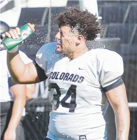  ?? Cliff Grassmick, Daily Camera ?? Colorado defensive end Mustafa Johnson tries to cool off during a sunny practice Saturday in Boulder.