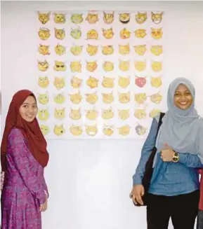  ??  ?? Beberapa pelajar bergambar bersama hasil seni yang dipamerkan pada Pameran Seni Lakar Wanita.