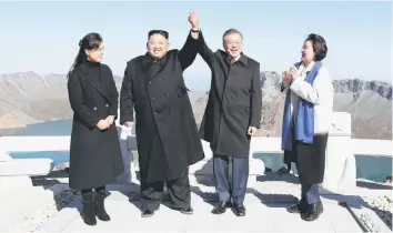  ?? — Reuters photo ?? Moon (second right) and Kim (second left) pose for photograph­s on the top of Mt Paektu, North Korea.