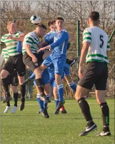  ??  ?? Andrew O’Brien of Greystones United looks on as Stephen Metcalfe and Jack Tanner challenge for the ball.