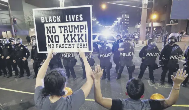  ?? PICTURE: MATT YORK/AP ?? 0 Protesters and police in a stand-off outside the Phoenix convention centre where President Donald Trump was holding a rally