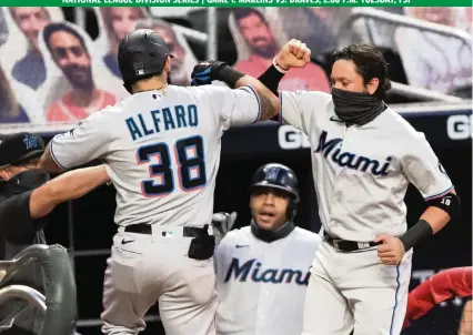  ?? CARMEN MANDATO Getty Images ?? Miguel Rojas, right, celebratin­g Jorge Alfaro’s home run against the Braves on Sept. 8, says, ‘Our game is fun. Our game is not the same as everyone else. We play our game like it’s the Little League World Series, and we’re going to keep it that way.’