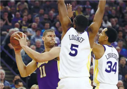  ?? AP FOTO/BEN MARGOT ?? COVER. Brook Lopez looks for an open teammate as Kevon Looney and Shaun Livingston cover him.