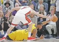  ?? THE ASSOCIATED PRESS ?? Pacers forward Thaddeus Young, on the floor, tries to pass around Heat guard Goran Dragic on Wednesday in Indianapol­is. Dragic scored 20 points in a 114-106 win.