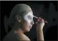 ?? DARKO VOJINOVIC - THE AP ?? In this July 27 photo, Serbian make-up artist Mirjana Milosevic known profession­ally as ‘Kika’ paints her face in her studio at her home in the central Serbian town of Smederevo, Serbia.