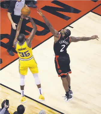  ?? Steve Russell / Toronto Star via Getty Images ?? The Warriors’ Kevin Durant nails a three-pointer to tie the game and send it to overtime despite defense by Toronto’s Kawhi Leonard, a two-time NBA Defensive Player of the Year.