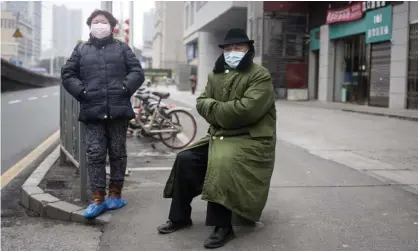  ?? Photograph: Stringer/Getty Images ?? Two residents wearing masks last January in Wuhan, China. On 11 January 2020, when Wuhan recorded its first Covid death, the virus’s genomic sequence was posted on an open access site.