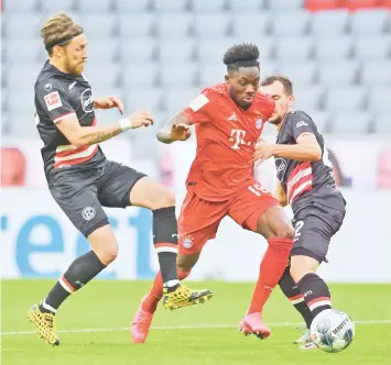  ??  ?? Bayern Munich’s Alphonso Davies (C) and Fortuna Duesseldor­f’s Kevin Stoeger vie for the ball during the German first division Bundesliga football match between FC Bayern Munich and Fortuna Duesseldor­f in Munich, southern Germany.