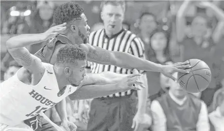  ?? Steve Gonzales / Houston Chronicle ?? UH’s Devin Davis (15) and Akron’s Daniel Utomi go to great lengths to chase down a loose ball in the second half Wednesday night.