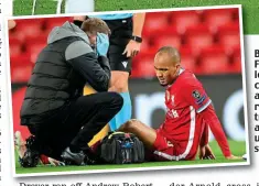  ?? AP ?? Big worry: Fabinho looks concerned as he receives treatment after pulling up in midstride