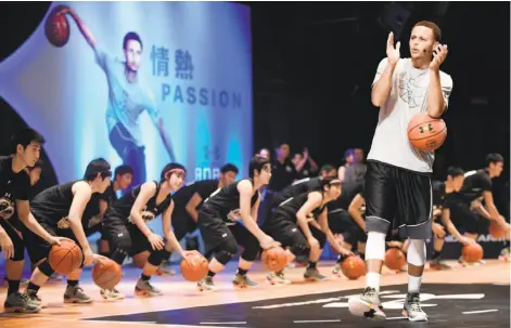  ?? Toshifumi Kitamura / AFP / Getty Images 2015 ?? Warriors star Stephen Curry, a two-time MVP, leads a basketball clinic in Tokyo during a 2015 tour for his sponsor, Under Armour.