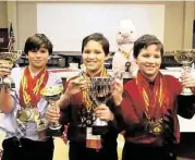  ?? Courtesy of Craig Sanders ?? Junior-level team members William Shein, left, Brady Sanders, and Colby Sanders received trophies after taking first place in the junior division at the Houston regionals of the World Scholar’s Cup.