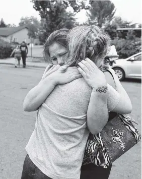  ?? AP PHOTO BY MARCIO JOSE SANCHEZ ?? Carla Bledsoe, facing camera, hugs her sister, Sherri, outside the sheriff’s office after hearing news that Sherri’s children James, 5, and Emily, 4, were killed in a wildfire Saturday in Redding, Calif.