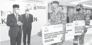  ??  ?? DIHARGAI: Hasni beramah mesra bersama petugas barisan hadapan yang menerima bantuan tunai RM200 di Bangunan Dato’ Jaafar Muhammad, Kota Iskandar semalam.