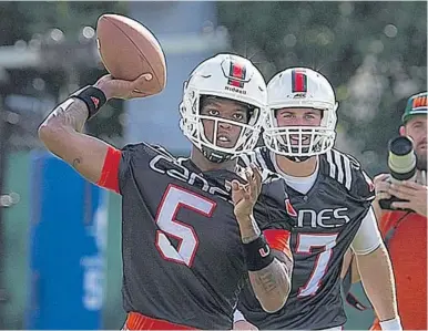  ?? PATRICK FARRELL/MIAMI HERALD ?? It’s a tight battle right now between N’Kosi Perry (5) and Cade Weldon (17) for the second spot at quarterbac­k behind Malik Rosier on the Miami Hurricanes’ roster.