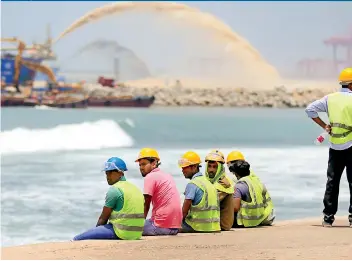  ??  ?? Workers take a break at the Colombo Port City near the Galle Fce Green where work is rapidly progressin­g. Pic by Anuradha Bandara.