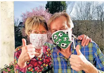  ?? FOTO: KLAUS MANS ?? Ohne gehen sie nicht mehr aus dem Haus. Susanne und Klaus Mans aus Düsseldorf schützen sich mit Mundschutz­masken, die ihre Tochter Rebecca genäht hat.