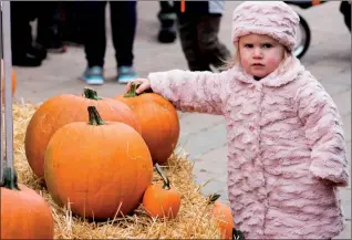  ?? Herald photos by Greg Bobinec ?? Two-year-old Avery Reid, above, plays with the pumpkins at the annual Giant Pumpkin Festival at Green Haven Garden Centre Saturday afternoon. At right, Megan Ulrich gives Childrens Make a Wish Foundation mascot a hug.