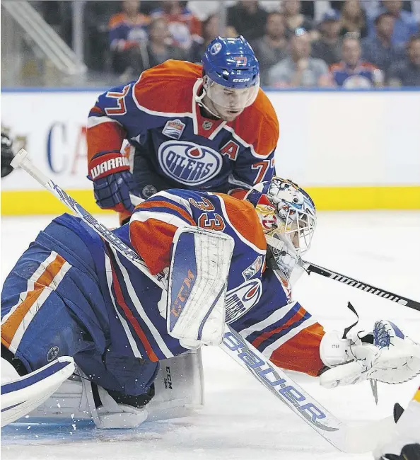  ?? CODIE MCLACHLAN/GETTY IMAGES ?? Cam Talbot makes a save against the Calgary Flames as Oscar Klefbom plays backup at Rogers Place on Monday.