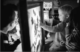  ??  ?? Children play with traditiona­l Chinese shadow puppets at Hatching Dragons. A third nursery is planned for next year in Westminste­r, London.