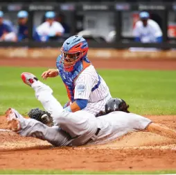  ?? (Reuters) ?? WASHINGTON NATIONALS baserunner Anthony Rendon slides to avoid the tag from New York Mets catcher Rene Rivera and scores a third-inning run in the Nationals’ 7-4 road victory on Saturday at Citi Field.